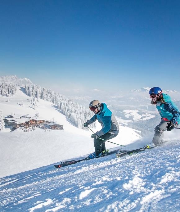 Skifahrer fahren die Piste herunter am Wilden Kaiser