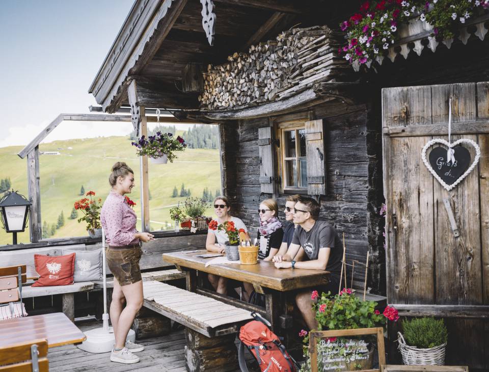 Gruppe macht Rast auf der Au Hochalm am Wilden Kaiser
