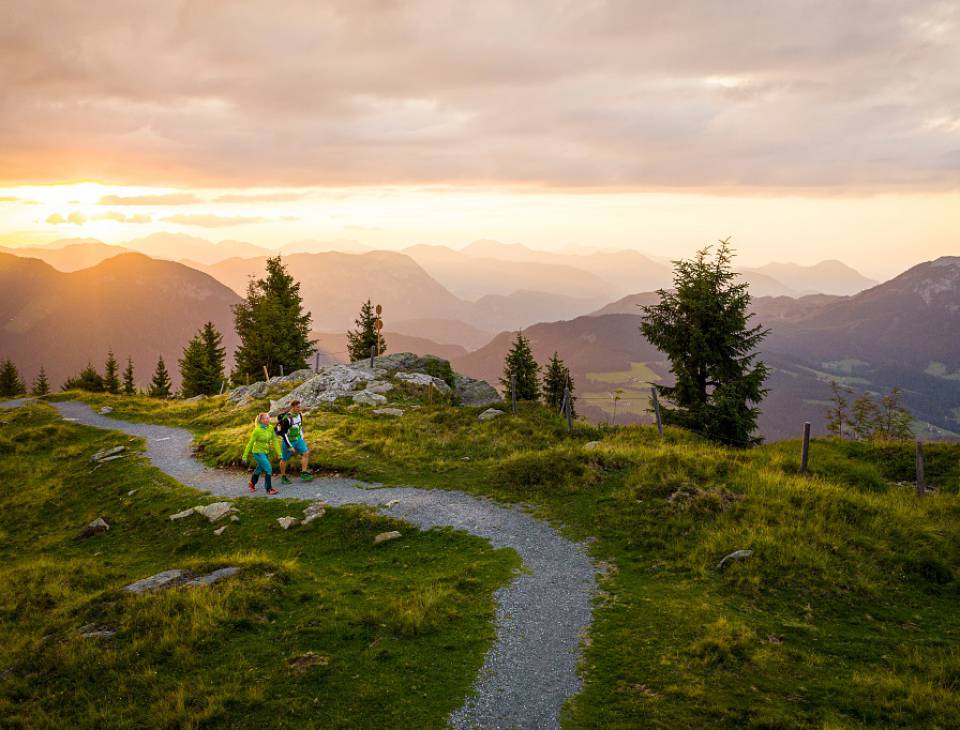 Wanderer wandern im Abendrot mit Blick auf die Region Wilden Kaiser